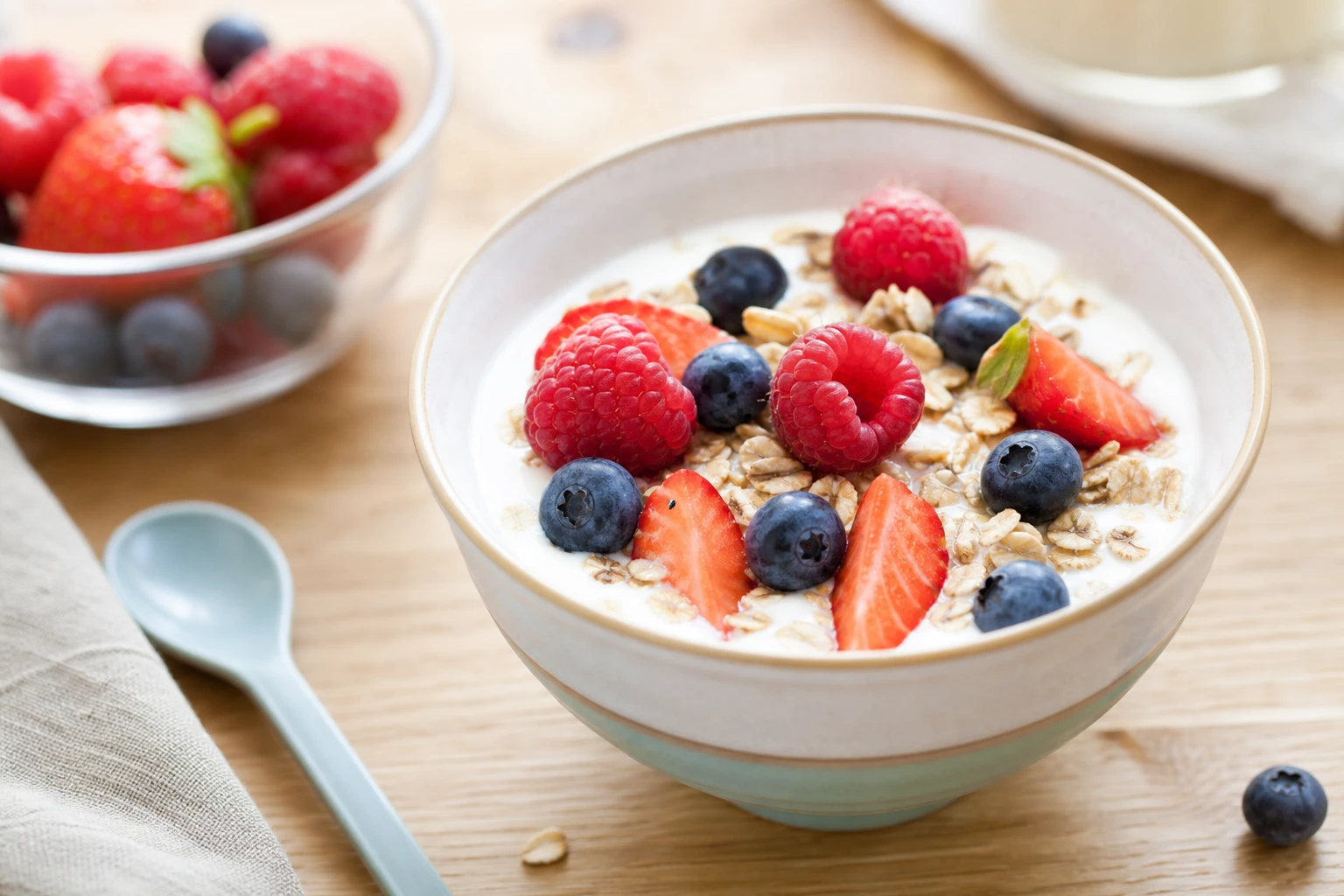 Bol de yaourt nature garni de flocons d'avoine et de fruits rouges, petit-déjeuner équilibré pour un enfant